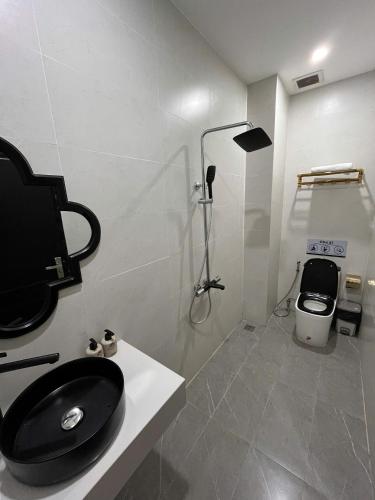 a bathroom with a black toilet and a shower at New Pearl Hotel HCM in Ho Chi Minh City