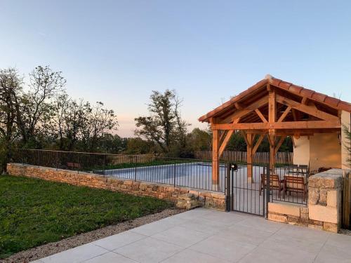 a pavilion with a fence next to a pool at Domaine de Pech Peyrat in Floressas