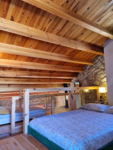a bedroom with wooden ceilings and a large bed at Casa Rural Haiku in Bojar