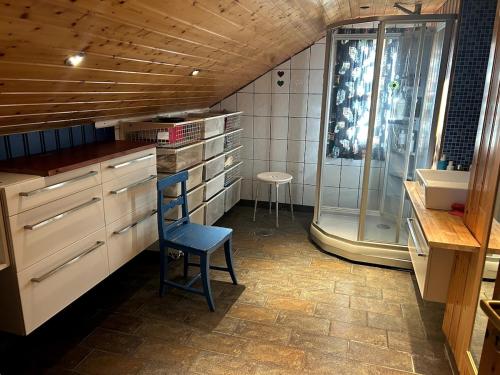 a kitchen with a blue chair and a shower at House at the farm! in Tromsø