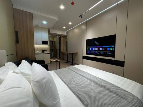 a bedroom with a large bed with a flat screen tv at Deluxe Studio NRG U-Tower in Tashkent