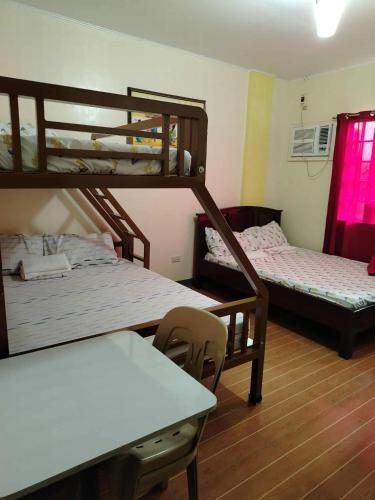 a room with two bunk beds and a table at Villa Elsie Resort and Hotel in General Trias