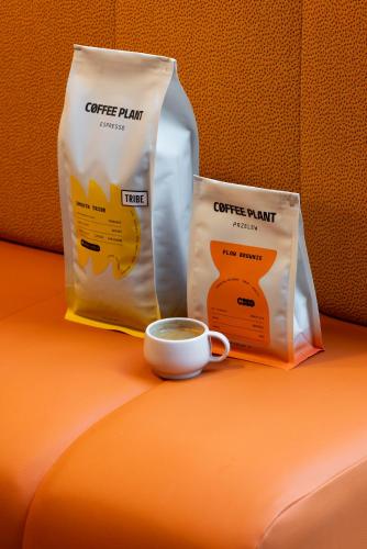 a cup of coffee and two bags of coffee paint at TRIBE Krakow Old Town in Kraków