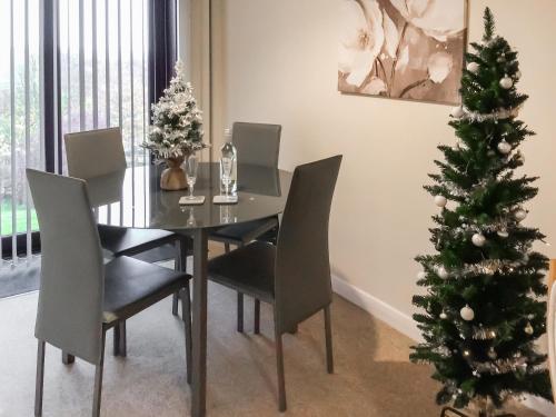 a dining room with a table and a christmas tree at Rosings in Bradfield