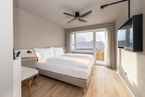 a bedroom with a bed and a ceiling fan at Giessen Hotel & Coffeehouse in Vaduz