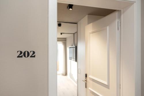 a door leading to a hallway with a television at Giessen Hotel & Coffeehouse in Vaduz