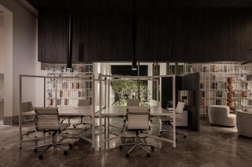 a dining room with a table and chairs and bookshelves at My Ōtel North Coast - Adult Only in Al Dabaa