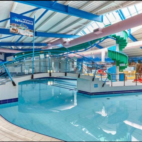 an indoor swimming pool with a pool slide at zucolli's Caravan at Trecco Bay Holiday Park in Porthcawl
