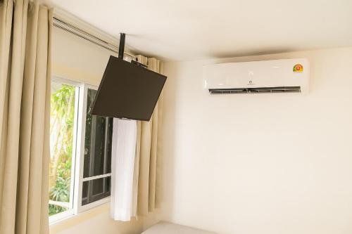 a television in a room with a window at Homeku Guesthouse Room 3 Cozy Stay Close to Suvarnabhumi Airport in Lat Krabang