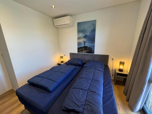 a bedroom with two beds and a painting on the wall at Enkhuizer Strand Chalet IJsselmeerblick Zweite Reihe mit Zaun Haus Nr 221 in Enkhuizen