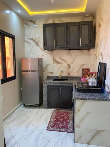 a kitchen with black cabinets and a stainless steel refrigerator at Atlantic coast imssouane in Imsouane