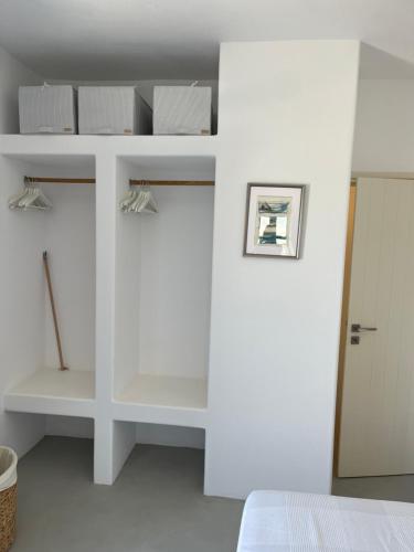 a bedroom with white walls and white shelves at Amorgos Elegant Houses, 6 Villas in Amorgos