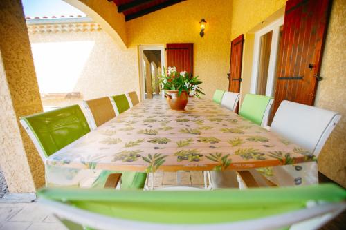 a dining room table with a vase on top of it at Les Villas de Perret in Joyeuse