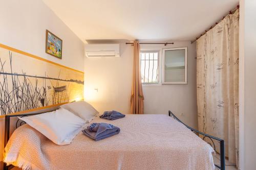 a bedroom with a bed with two towels on it at Villa Salamandre in Saint-Louis-du-Rhône