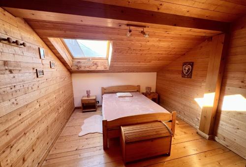 una camera da letto con un letto in una cabina di legno di Perce Neige Bien être a La Bresse