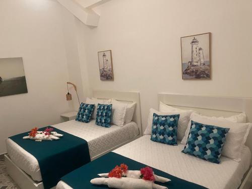 two beds in a room with blue and white at Hotel Boutique Brisas Colonial in Santo Domingo