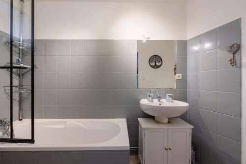 a bathroom with a tub and a sink and a bath tub at Le Cocoon CléJa - Proche Station La Bresse in Ventron
