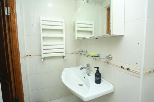 a white bathroom with a sink and a mirror at Best Atmosphere Hostel in Baku