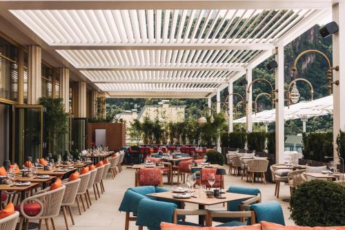 an outdoor dining area with tables and chairs at Falkensteiner Hotel Bozen WaltherPark in Bolzano