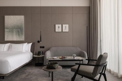 a hotel room with a bed and a table and a chair at My Ōtel North Coast - Adult Only in Al Dabaa