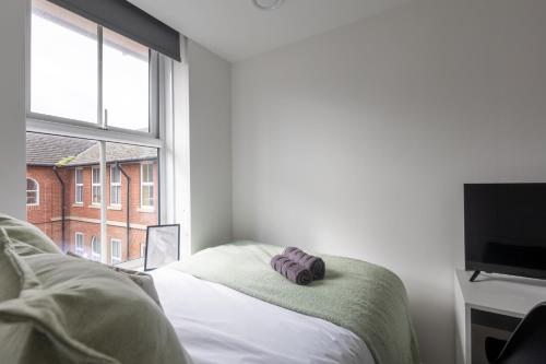 a bedroom with a bed and a tv and a window at St James Court Hotel in Derby