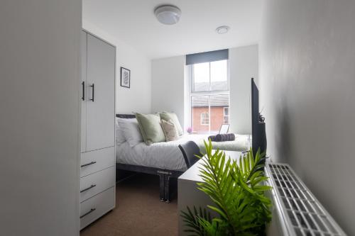 a white living room with a couch and a window at St James Court Hotel in Derby