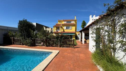 a house with a swimming pool in front of a house at Oceans House Villa in Carcavelos