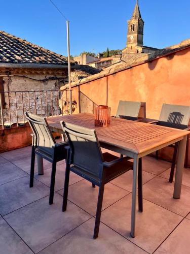 a wooden table and chairs sitting on a patio at Beautiful Village Silk House, with terrace in Collias