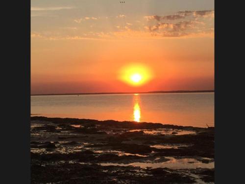 a sunset over the water with the sun setting at The Van 2 Park amenities are seasonal in Porchfield