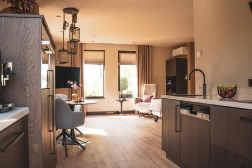 eine Küche mit Tisch und Stühlen in einem Zimmer in der Unterkunft Bij Corine, bed en zorg in Altforst