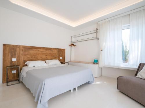 a white bedroom with a bed and a couch at Valentino Luxury Rooms in Porto Cesareo