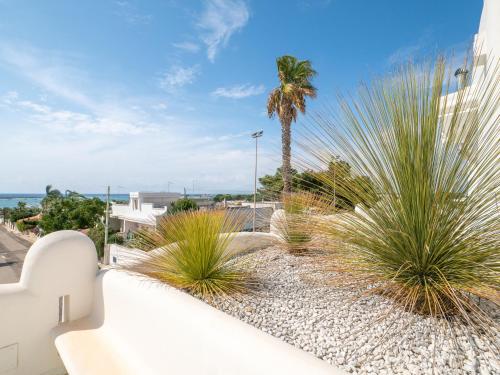 a balcony with a palm tree and a building at Valentino Luxury Rooms in Porto Cesareo