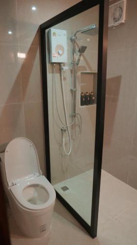 a bathroom with a shower and a toilet in a room at West Mount Cafe & Restaurant in Ban Hua Hin