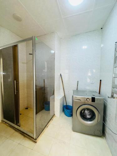 a bathroom with a washing machine and a shower at Nizami Hostel in Baku