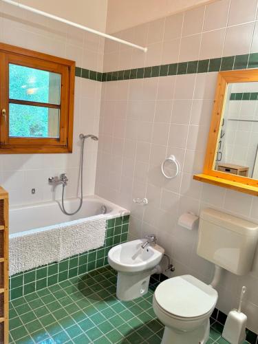 a bathroom with a toilet and a tub and a sink at Crans-Montana 3BR - Mountain View, Balcony and Parking in Crans-Montana