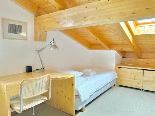 a bedroom with a desk and a bed in a room at Crans-Montana 3BR - Mountain View, Balcony and Parking in Crans-Montana