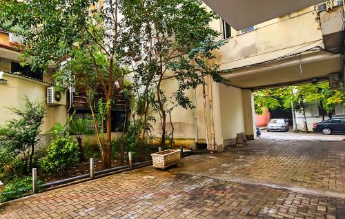 a building with a parking garage with trees in it at Tirana Heart Lodge in Tirana