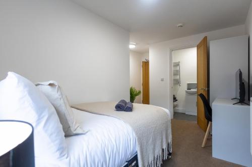 a bedroom with a white bed and a television at St James Court Hotel in Derby