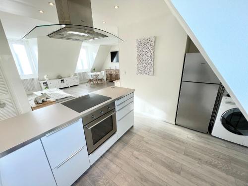 Ideally located , Eiffel Tower view في نويي سور سين: مطبخ بخزائن بيضاء وثلاجة من الفولاذ المقاوم للصدأ