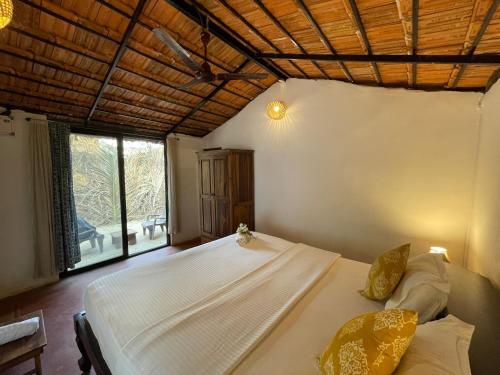a bedroom with a bed and a large window at SPACELAND Mandrem in Mandrem