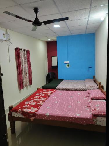 a bedroom with a bed and a blue wall at Radhe Homestay Malpe Beach side, udupi in Malpe
