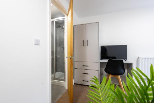 a white cabinet with a desk and a chair at St James Court Hotel in Derby