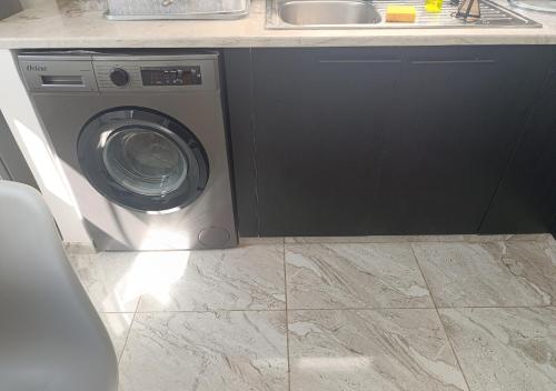 a washing machine in a kitchen next to a sink at charming bright house la marsa in Dar Tahar Zaouch