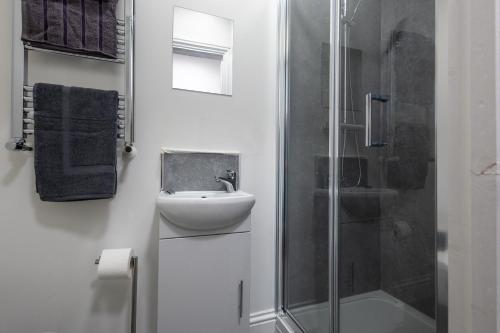 a white bathroom with a sink and a shower at St James Court Hotel in Derby