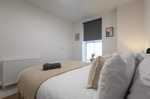 a bedroom with a bed with white sheets and a window at St James Court Hotel in Derby