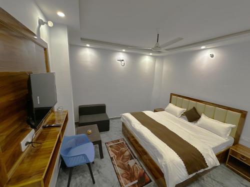 a bedroom with a bed and a flat screen tv at Divya Ganga - Shivpuri, Rishikesh in Shivpuri