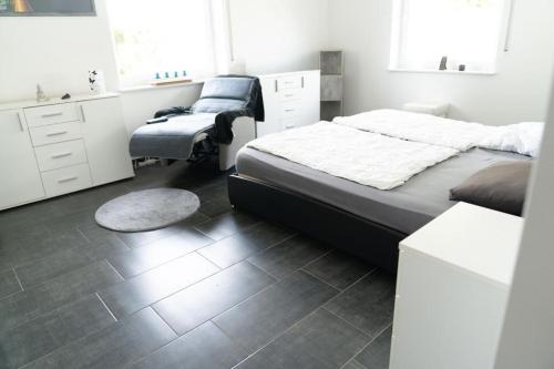 Un dormitorio con una cama, un escritorio y una silla. en NEU! Ferienhaus Mein Geestland, en Imsum
