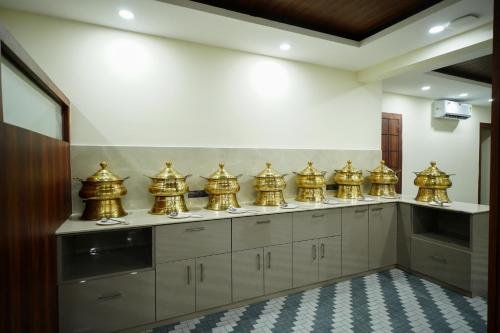 a row of gold containers on a counter in a kitchen at Hotel Royal International - Best Boutique Hotel Near Airport & Kamakhya Temple in Guwahati