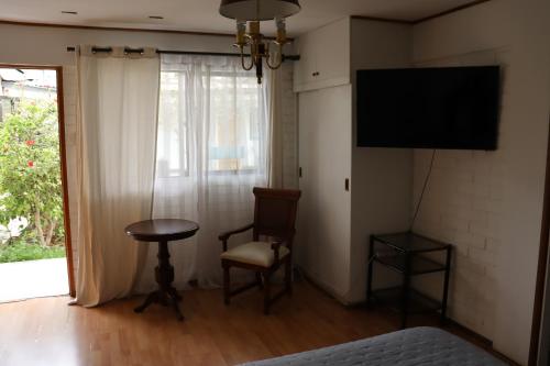 a room with a tv and a chair and a table at Hotel Montecatini I in Copiapó