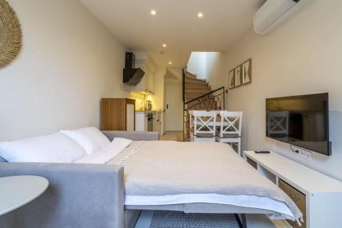 una camera da letto con un letto e una tv di Naro Suites Alaçatı Köyiçi a Çeşme